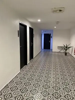 an empty hallway with black doors and a tile floor at Georgetown Inn by Sky Hive in George Town