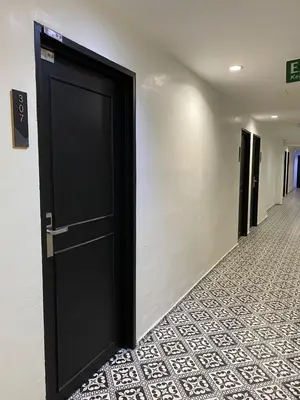 a black door in a hallway with a tile floor at Georgetown Inn by Sky Hive in George Town