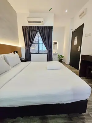 a bedroom with a large white bed and a window at Georgetown Inn by Sky Hive in George Town
