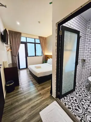 a hotel room with a bed and a shower at Georgetown Inn by Sky Hive in George Town