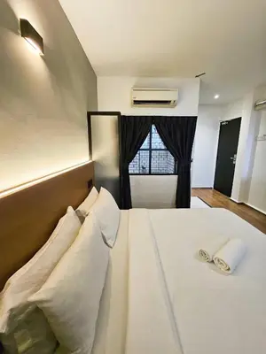 a bedroom with a bed with pillows and a window at Georgetown Inn by Sky Hive in George Town