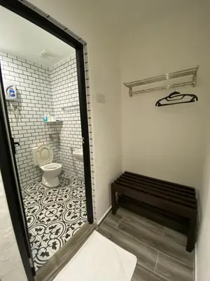 a small bathroom with a toilet and a bench at Georgetown Inn by Sky Hive in George Town