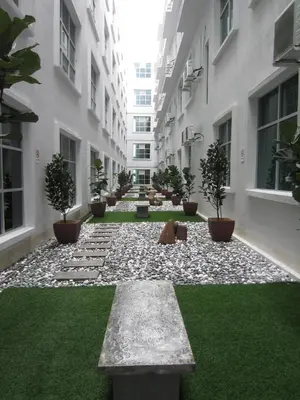a courtyard of a building with plants and grass at D Hotel in Seri Iskandar
