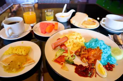 a table topped with plates of food and drinks at Armenian Street Heritage Hotel in George Town