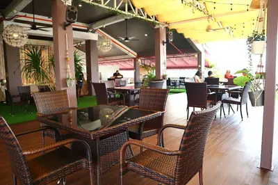 a restaurant with tables and chairs and people sitting at tables at Armenian Street Heritage Hotel in George Town