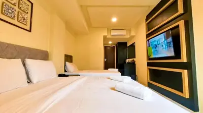 a hotel room with a bed and a tv at Bishop Hotel in George Town