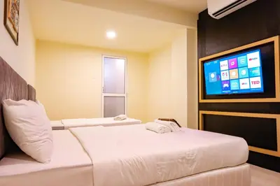 a hotel room with two beds and a flat screen tv at Bishop Hotel in George Town