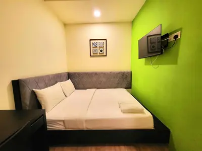 a small room with a bed with a green wall at Bishop Hotel in George Town