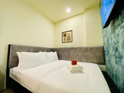 a hotel room with a bed with a flower on it at Bishop Hotel in George Town