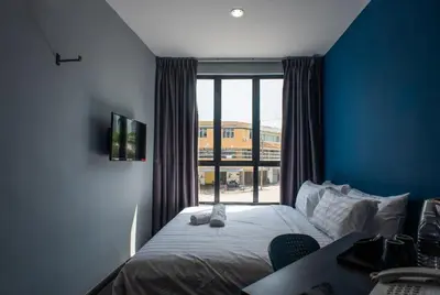 a hotel room with a bed and a window at Chariton Hotel Bagan in Butterworth