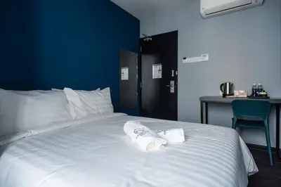 a white bed with two towels on top of it at Chariton Hotel Bagan in Butterworth