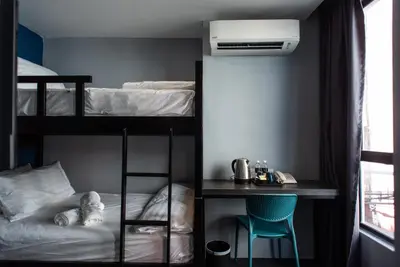 a bedroom with a bunk bed with a desk at Chariton Hotel Bagan in Butterworth