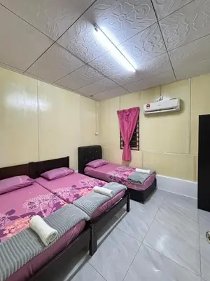 two beds in a room with pink sheets at Homestay Teduhan Gunung, Gopeng in Gopeng