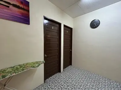 a room with a door and a clock on the wall at Minden Stay in Gelugor