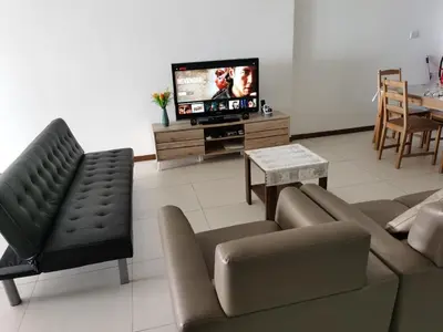 a living room with a couch and a tv at Landmark Stunning High Floor Coast View Studio #Netflix #Fast Wifi in Tanjong Tokong