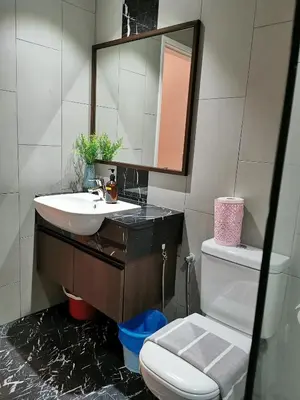 a bathroom with a sink and a toilet and a mirror at Landmark Stunning High Floor Coast View Studio #Netflix #Fast Wifi in Tanjong Tokong