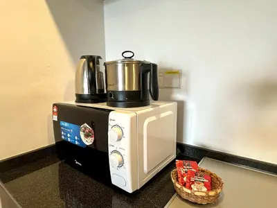 a microwave with a coffee pot on top of it at Landmark Stunning High Floor Coast View Studio #Netflix #Fast Wifi in Tanjong Tokong