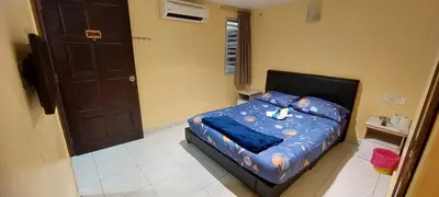 a bedroom with a bed with a blue comforter at RELAX HOTEL in Sungai Petani