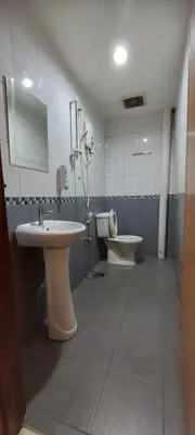 a bathroom with two sinks and a toilet and a mirror at RELAX HOTEL in Sungai Petani