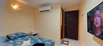 a bedroom with a bed and a television with a woman at RELAX HOTEL in Sungai Petani