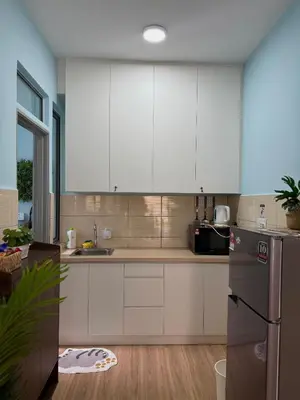 a kitchen with white cabinets and a refrigerator at Mama King’s Homestay@ Palas Horizon in Brinchang