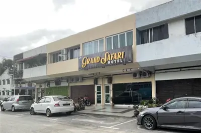 a building with cars parked in a parking lot at OYO 90369 Safari Hotel Lumut in Kampong Pundut