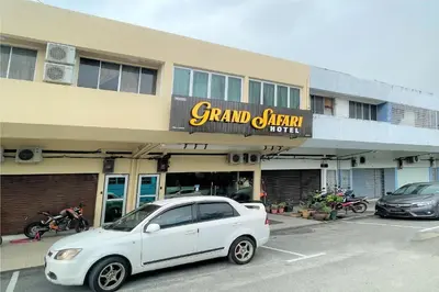 a white car parked in a parking lot in front of a building at OYO 90369 Safari Hotel Lumut in Kampong Pundut