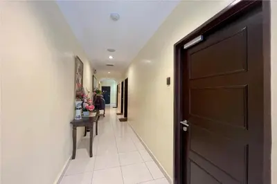 a hallway with a black door and a table at OYO 90369 Safari Hotel Lumut in Kampong Pundut