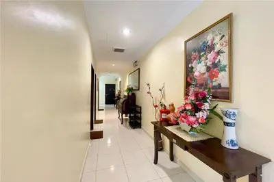 a hallway with a vase of flowers on a table at OYO 90369 Safari Hotel Lumut in Kampong Pundut