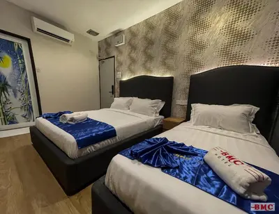 two beds in a hotel room with two at BMC Hotel in Ipoh