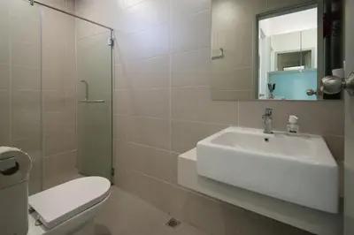 a bathroom with a sink and a toilet and a mirror at Straits Garden Suites by The Homestay Helper in George Town