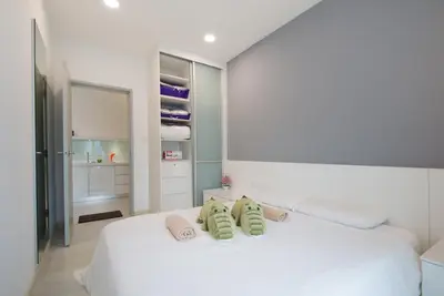 a bedroom with a white bed with two pillows on it at Straits Garden Suites by The Homestay Helper in George Town