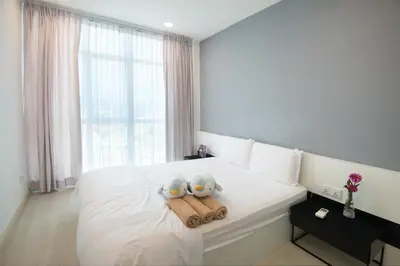 two stuffed animals sitting on a bed with towels at Straits Garden Suites by The Homestay Helper in George Town