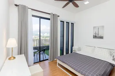 a bedroom with a bed and a balcony at Beacon Executive Suite Penang in George Town