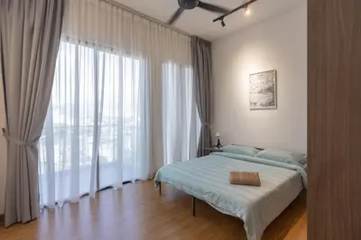 a bedroom with a bed and a large window at Beacon Executive Suite Penang in George Town