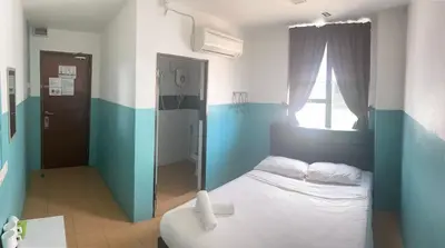 a blue and white bedroom with a bed and a window at Lih Pin Hotel in Sungai Petani