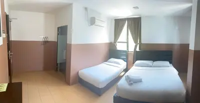 a hotel room with two beds and a window at Lih Pin Hotel in Sungai Petani