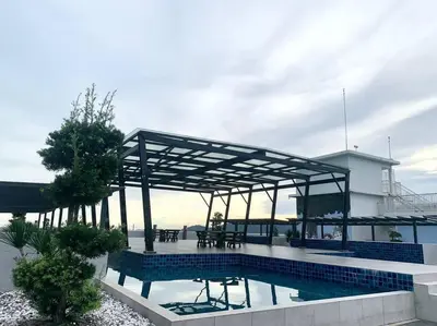 a swimming pool with a pavilion next to a building at The Venus - Spacious Wooden TOP Floor Apartment in Sitiawan
