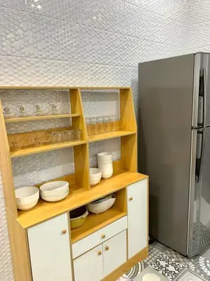 a kitchen with a refrigerator and white bowls and plates at The Venus - Spacious Wooden TOP Floor Apartment in Sitiawan