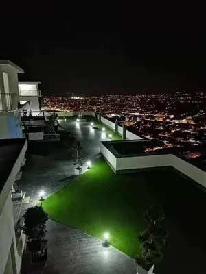 a night view of a building with a green lawn at WL Homestay in Sitiawan