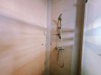 a shower with a shower head in a bathroom at Nova Apartments near Kea Farm in Brinchang