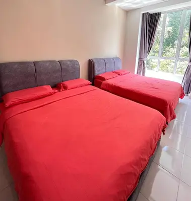 two beds with red sheets in a room with a window at Cameron Emerald Avenue 2 @ Brinchang in Brinchang