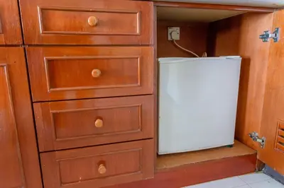 a small white refrigerator sitting in a closet at J Beach Suites At Rainbow Paradise in Tanjung Bungah