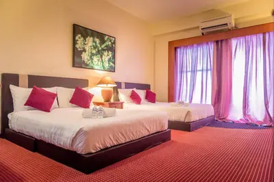 a hotel room with two beds and a window at J Beach Suites At Rainbow Paradise in Tanjung Bungah