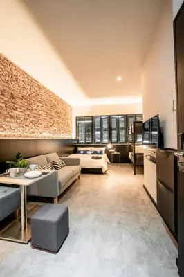 a living room with two couches and a brick wall at Chulia Heritage Studio in George Town