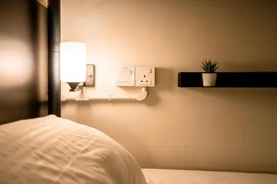 a bedroom with a bed and a light on a wall at Chulia Heritage Studio in George Town