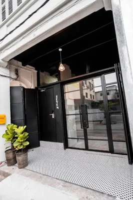 a garage with a black door and some plants at Chulia Heritage Studio in George Town