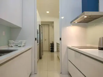 a large kitchen with white counters and a hallway at Jazz Suites Apartment Penang By Jazz Service Suite in Bagan Jermal