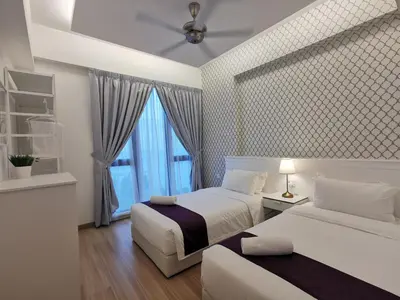 a bedroom with two beds and a window at Jazz Suites Apartment Penang By Jazz Service Suite in Bagan Jermal
