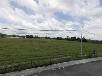 a person standing in a field next to a fence at LYNN HOMESTAY SERI ISKANDAR in Seri Iskandar